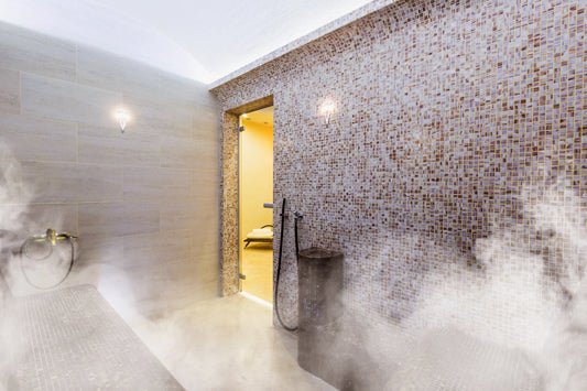 Turkish bath with steam and towels rolled up on a chair.