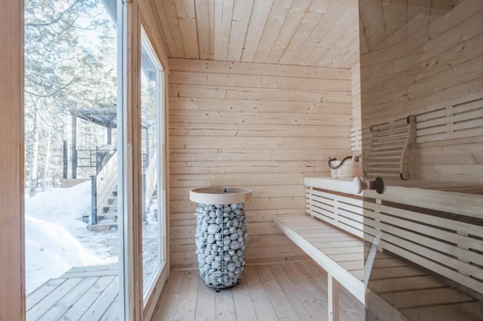 Bench and bucket of stones in sauna room.