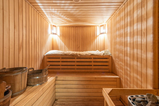 Wooden sauna with bench and bucket.