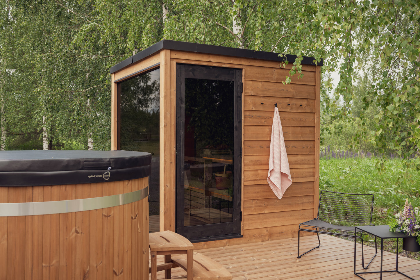 Nordic Dawn outdoor sauna with glass door and wooden benches.