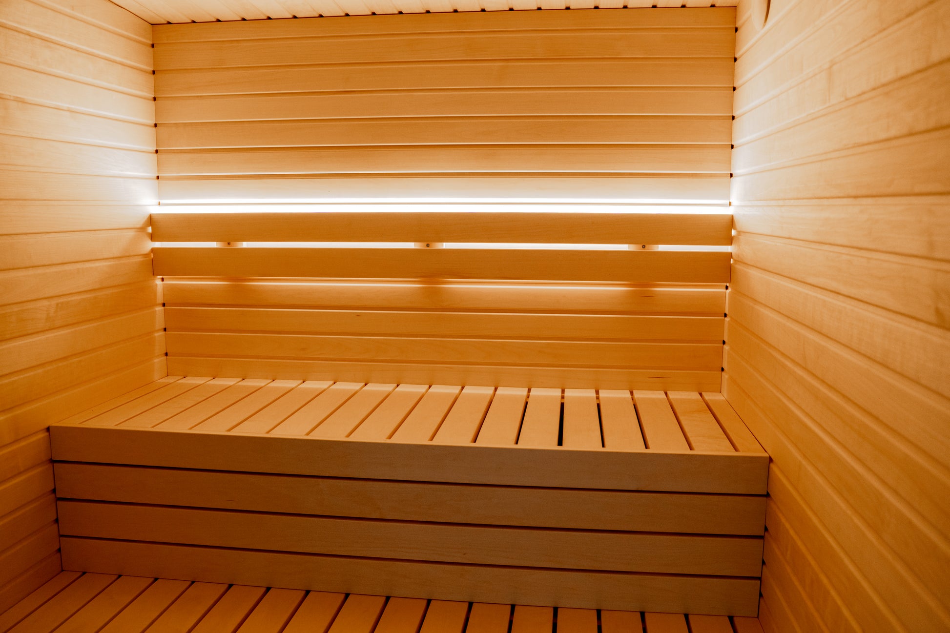 Wooden bench in the outdoor sauna Saunamo Lumi.