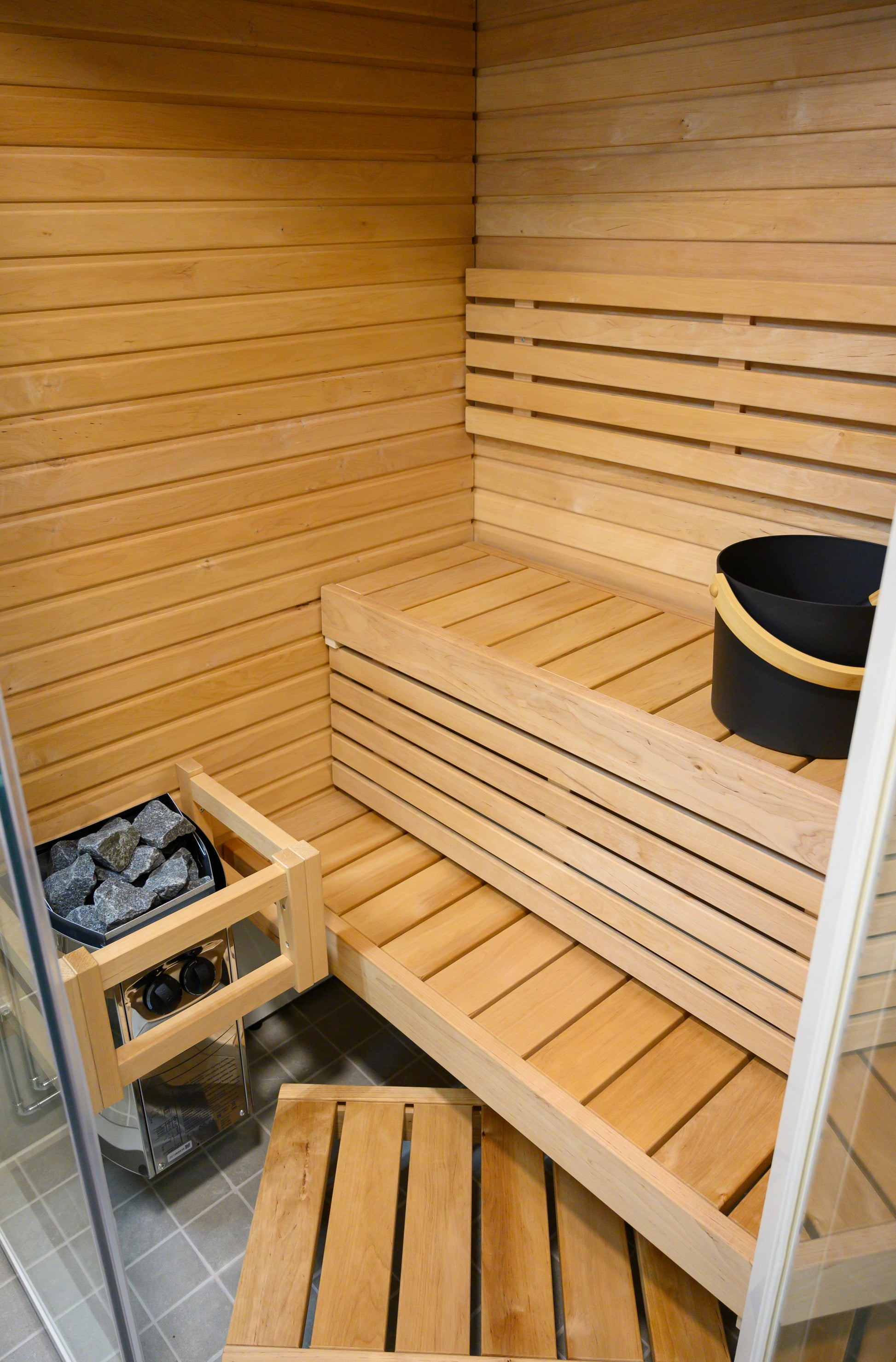 Sirius Corner sauna with bucket and stones.