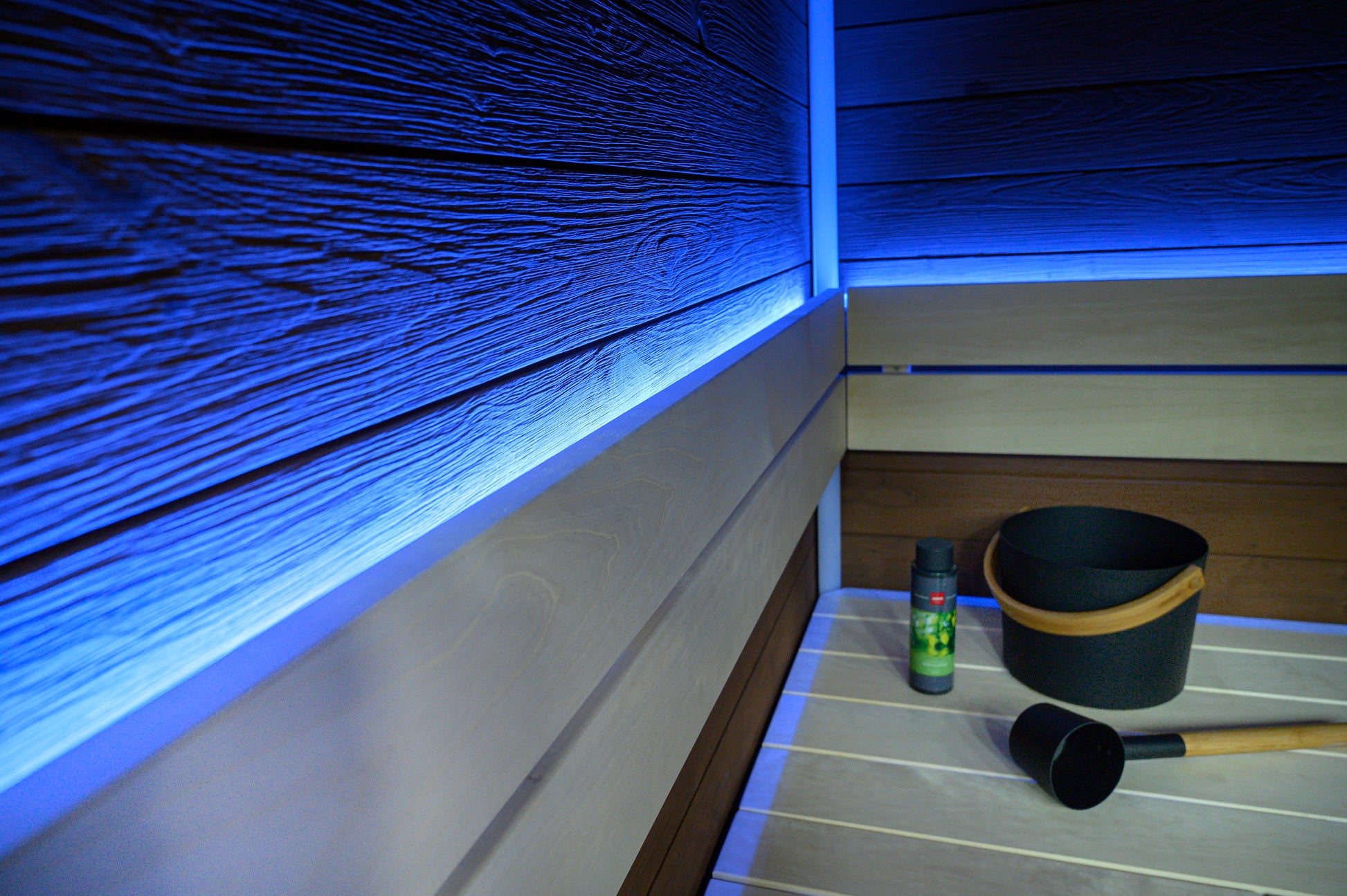 Block sauna with LED lighting and black bucket.