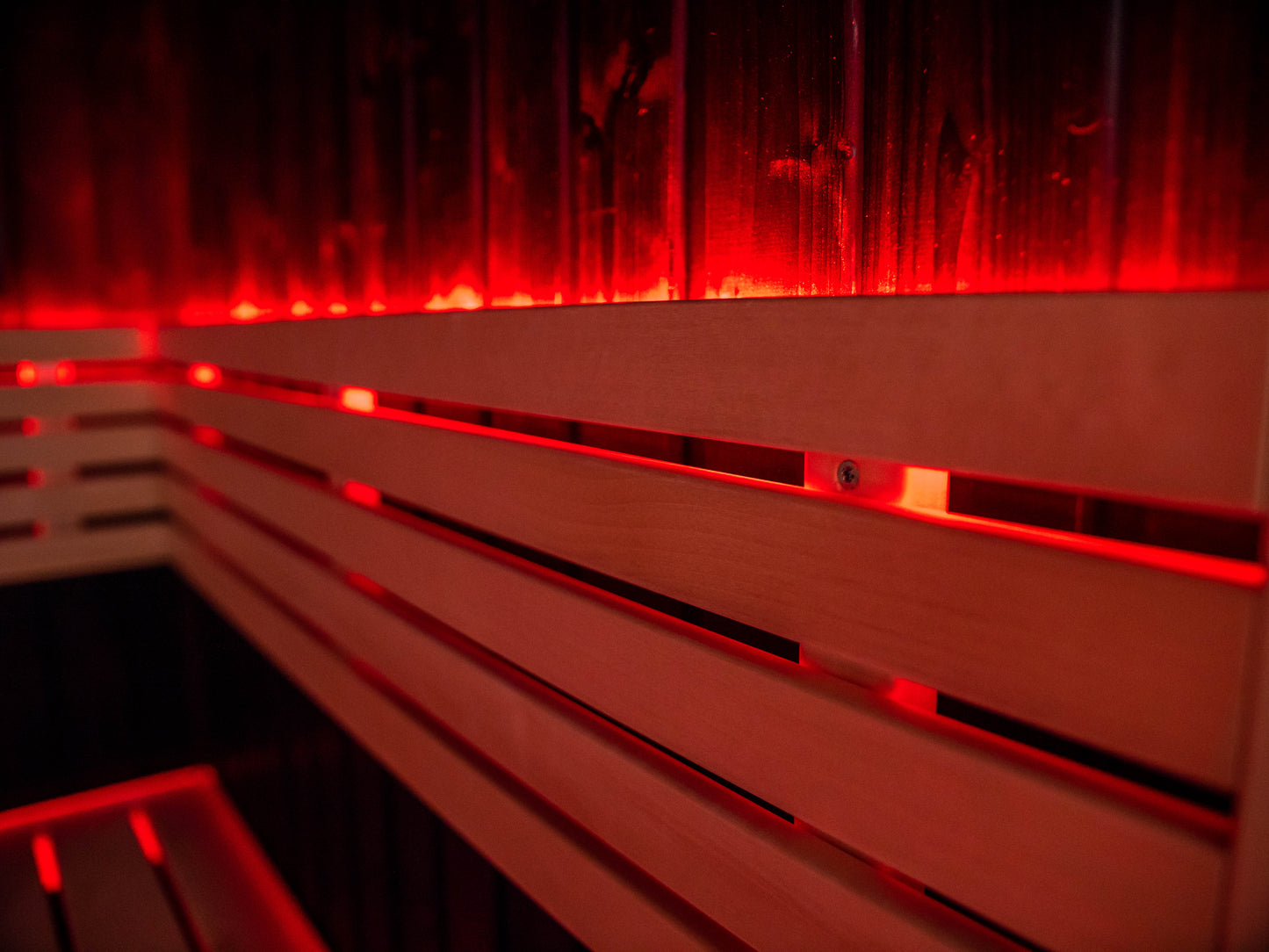 Fenix sauna with red LED light on wooden bench.