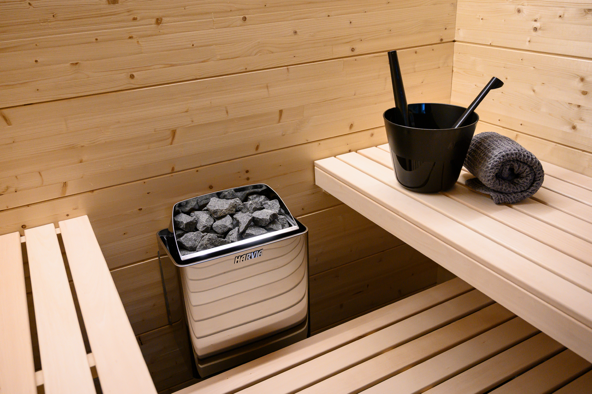 Harvia KIP electric heater in sauna with stone bucket.