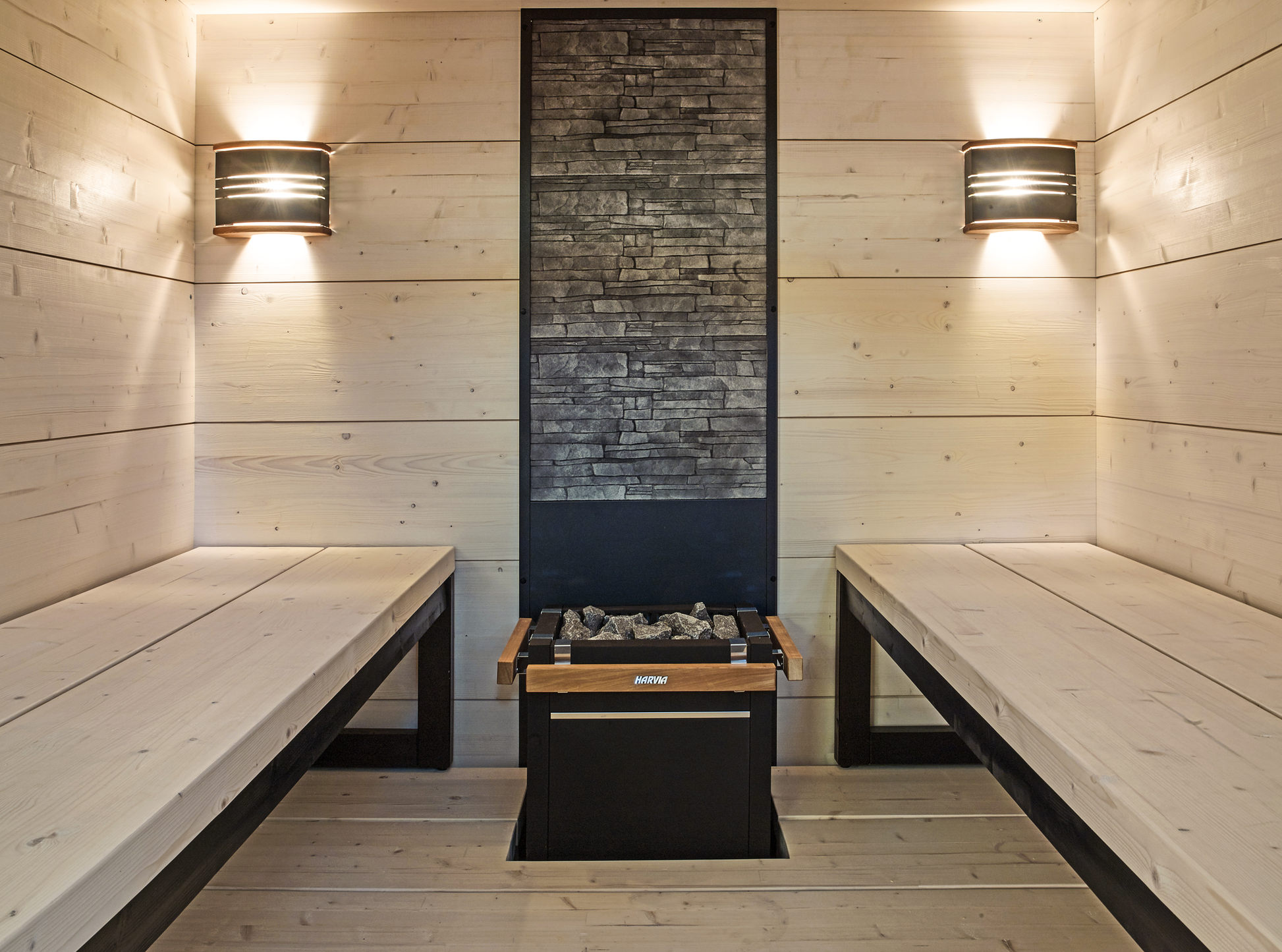 Solide sauna with wooden benches and fireplace.