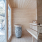 Outdoor sauna Saunamo Nordica with bench and stone bucket.