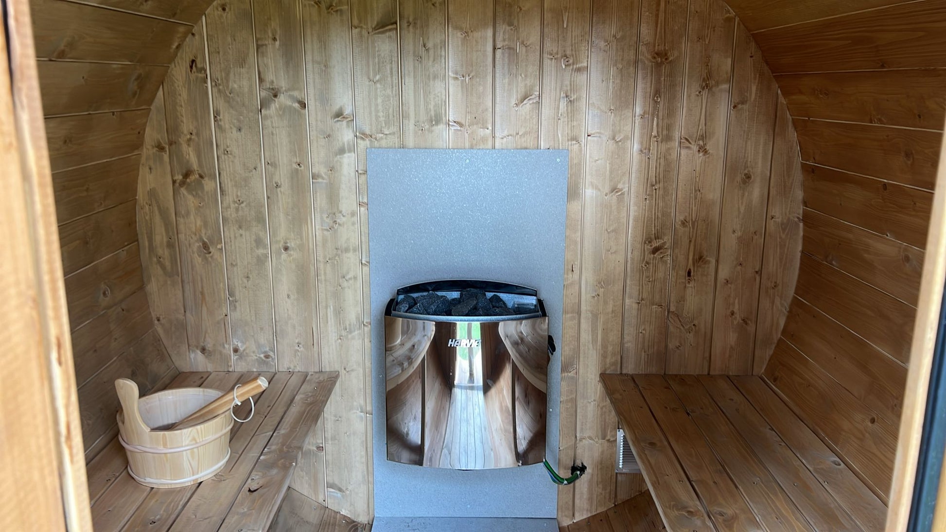 Outdoor sauna 230 with visible bucket and heater.