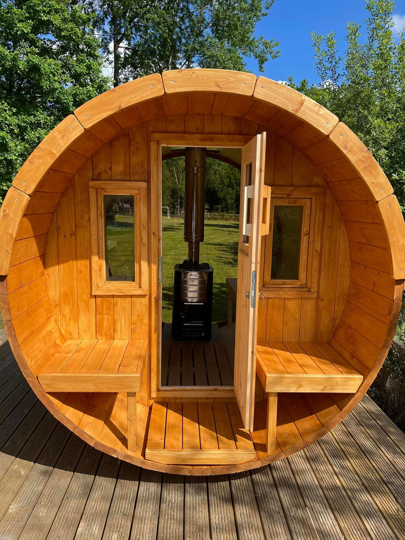 Outdoor sauna Saunamo Barrel 250 in wood with door and benches.