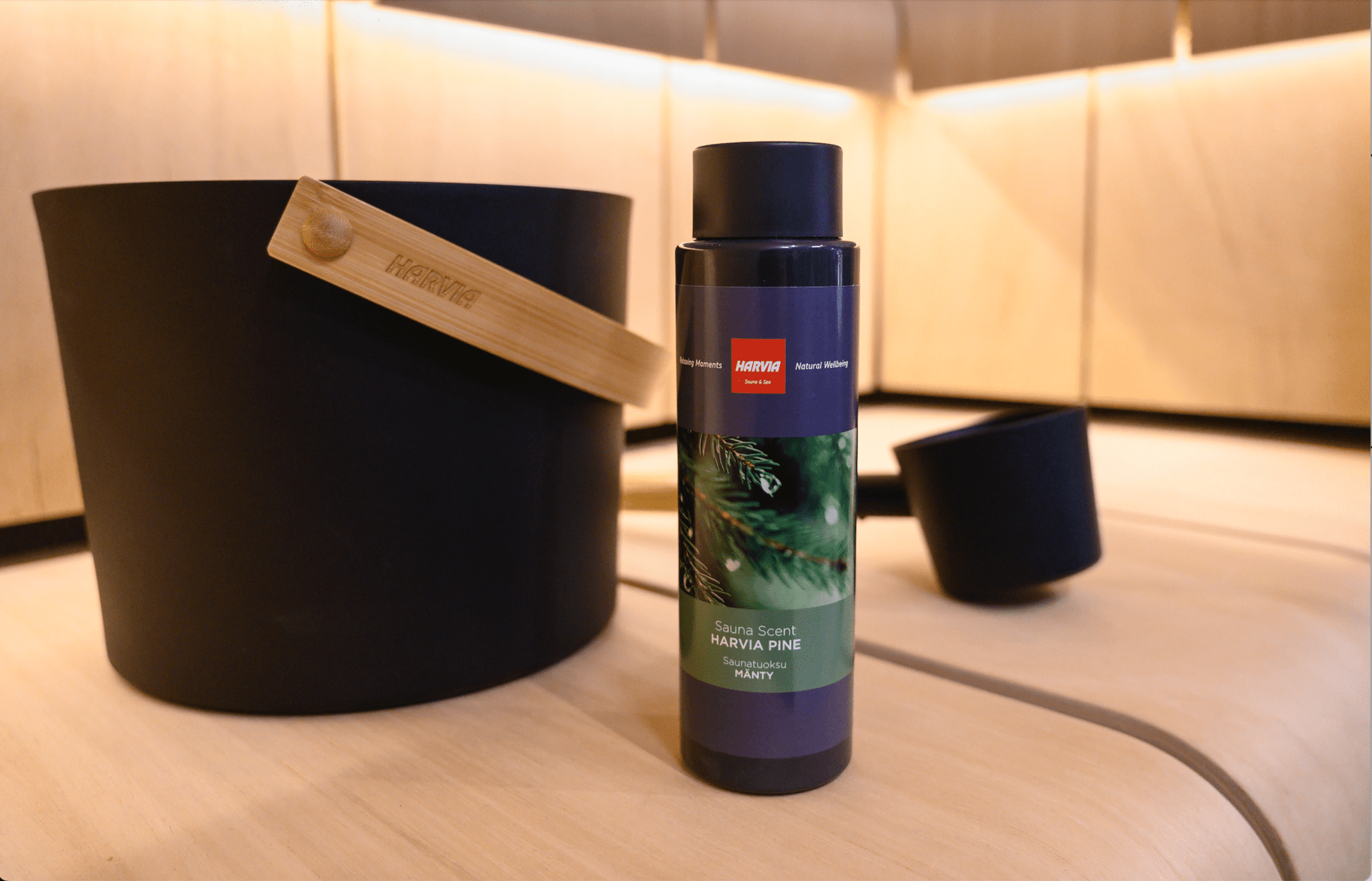 Essência de Sauna Harvia – Aroma de Pinho, garrafa ao lado de balde.