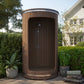 Outdoor barrel shower with plants all around.