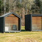 LUMI outdoor sauna insulated with a glass door, in a green area.