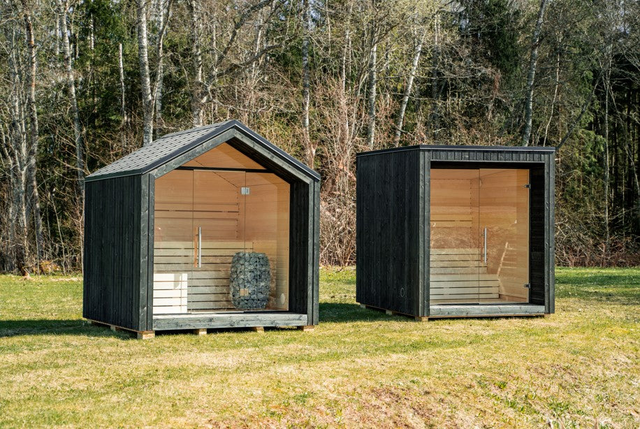 LUMI outdoor sauna insulated with a glass door, in a green area.