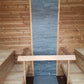 Sauna Saunamo Cubus with stone wall and wooden benches.