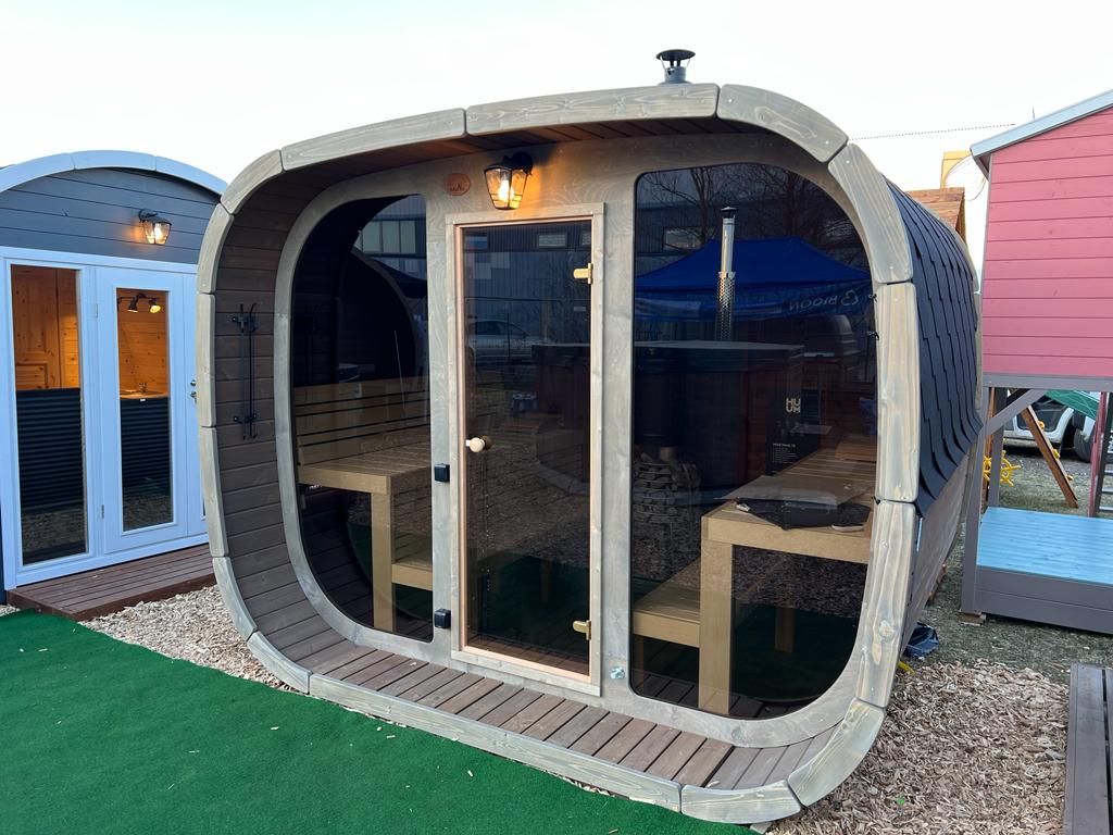 Sauna Saunamo Cubus with glass door and wooden structure.