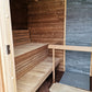 Sauna Saunamo Cubus with partial stone wall.